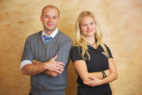 Two people smiling at the camera with their arms crossed. And example of Twin Cities Business Portraits