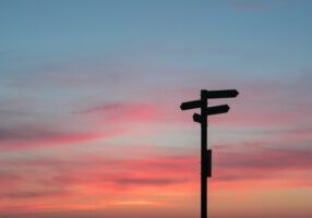 Sign posts with a sunset behind